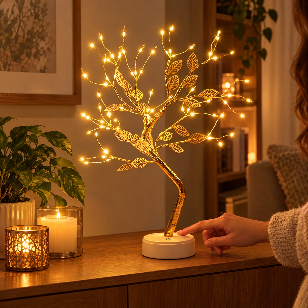 Golden leaf LED tree lamp glowing on a sideboard