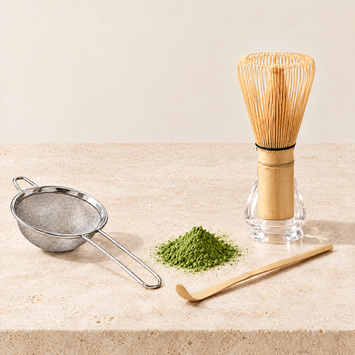 Bamboo matcha whisk on clear holder with scoop and strainer